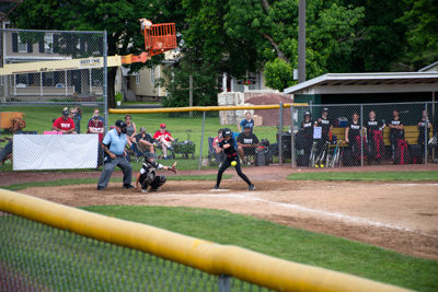 Batter, catcher and umpire with ball right in front of batter.