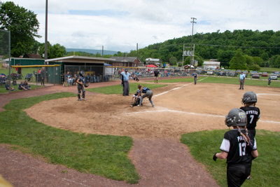 Runner sliding into home plate as catcher tries to tag her out.