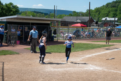 Runner tagging home plate as catcher watches.