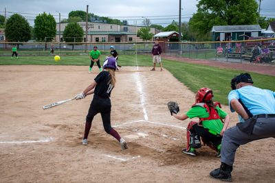 Umpire, catcher and batter just after striking the ball.