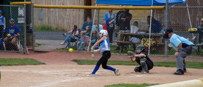 Umpire and catcher watching batter swing about to hit ball.