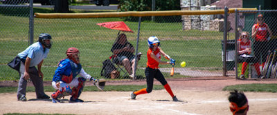 Batter mid swing about to hit ball.