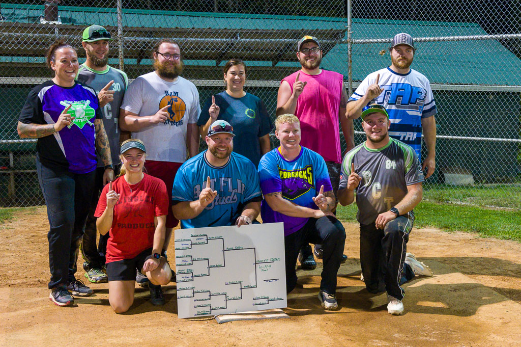 The winning team: Master Batters posing on home plate with the bracket displayed.