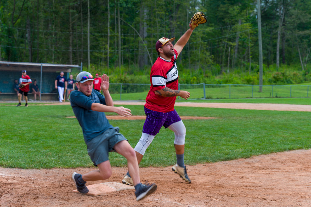 First baseman catches ball as runner crosses first base.