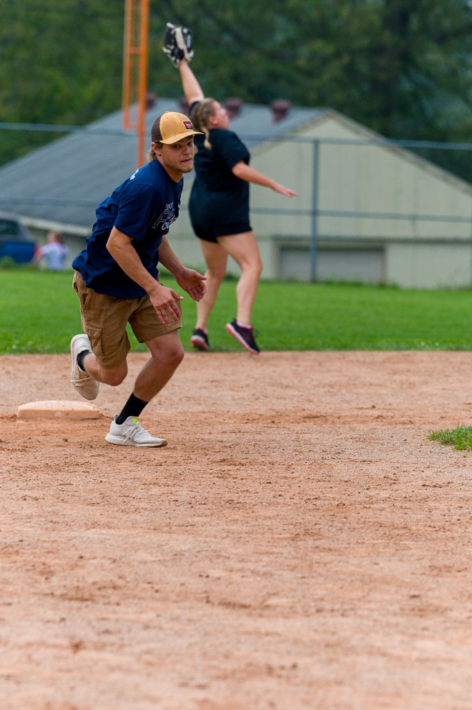 Runner heads for third as second baseman jumps to catch ball.