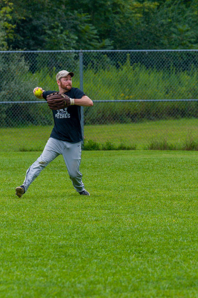 Outfielder winds up to throw ball to infield.