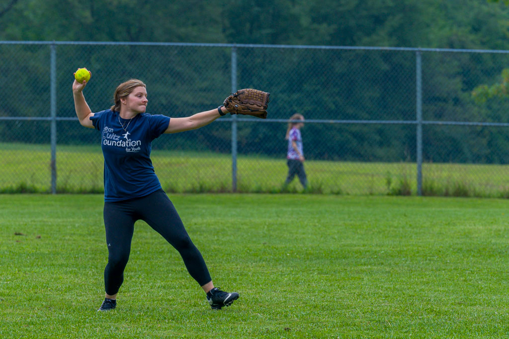 Outfielder winds up to throw ball to infield.