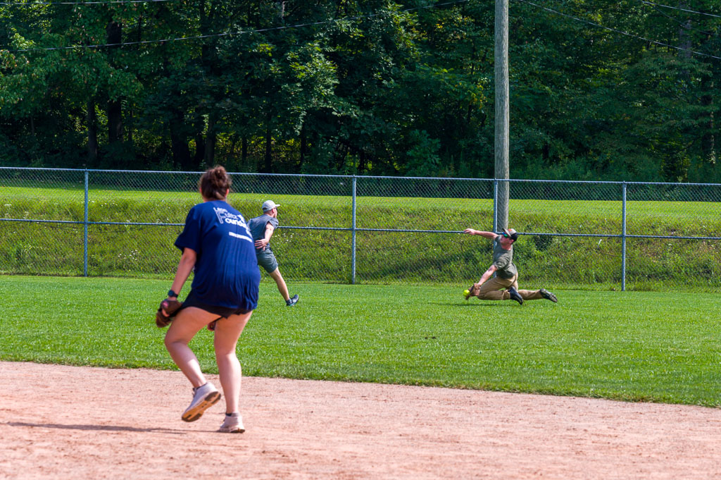 Outfielder dives to catch ball.