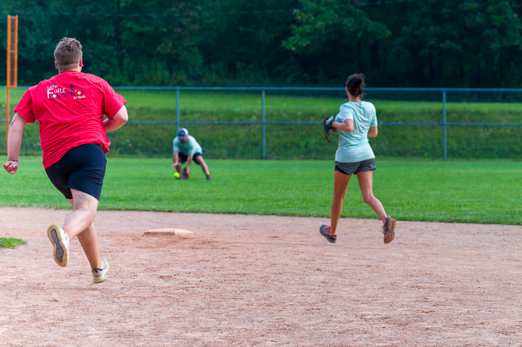 Outfielder catches ball as runner approaches second base.