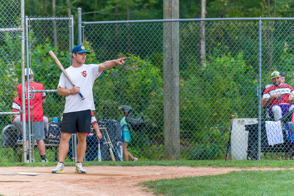 Player about to bat is pointing to the outfield.