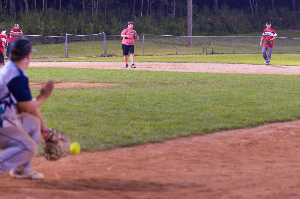 First baseman is just about to catch ball.