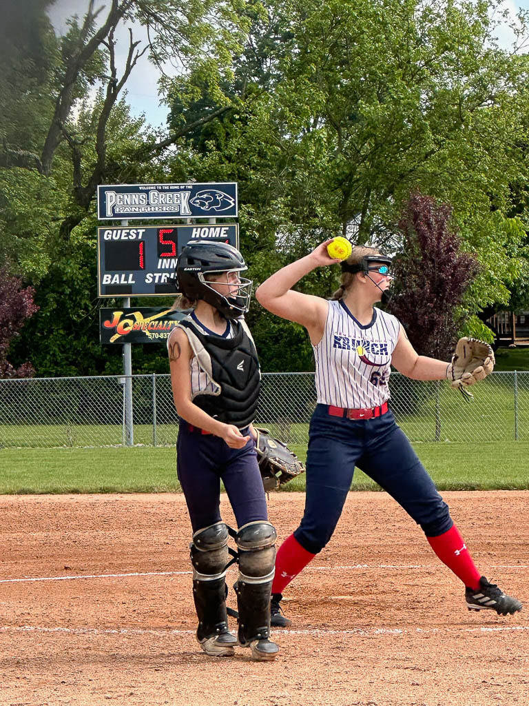 Catcher heading back to home plate as pitcher prepares to throw to first baseman.