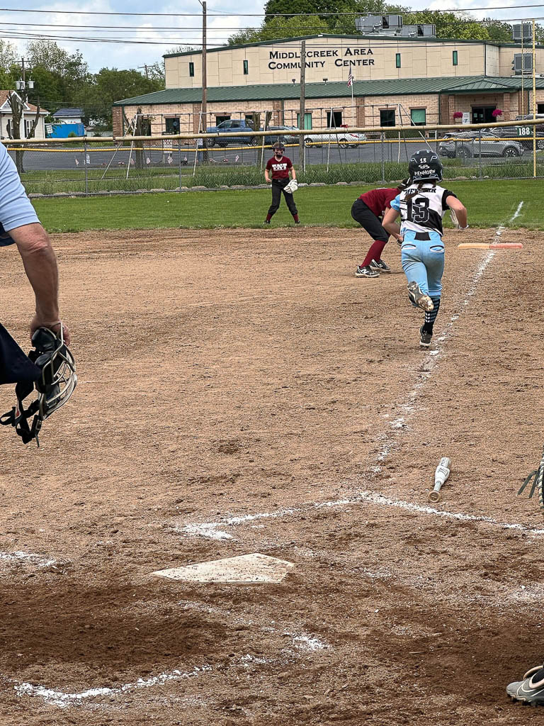 Catcher runs towards first base to catch the ball.