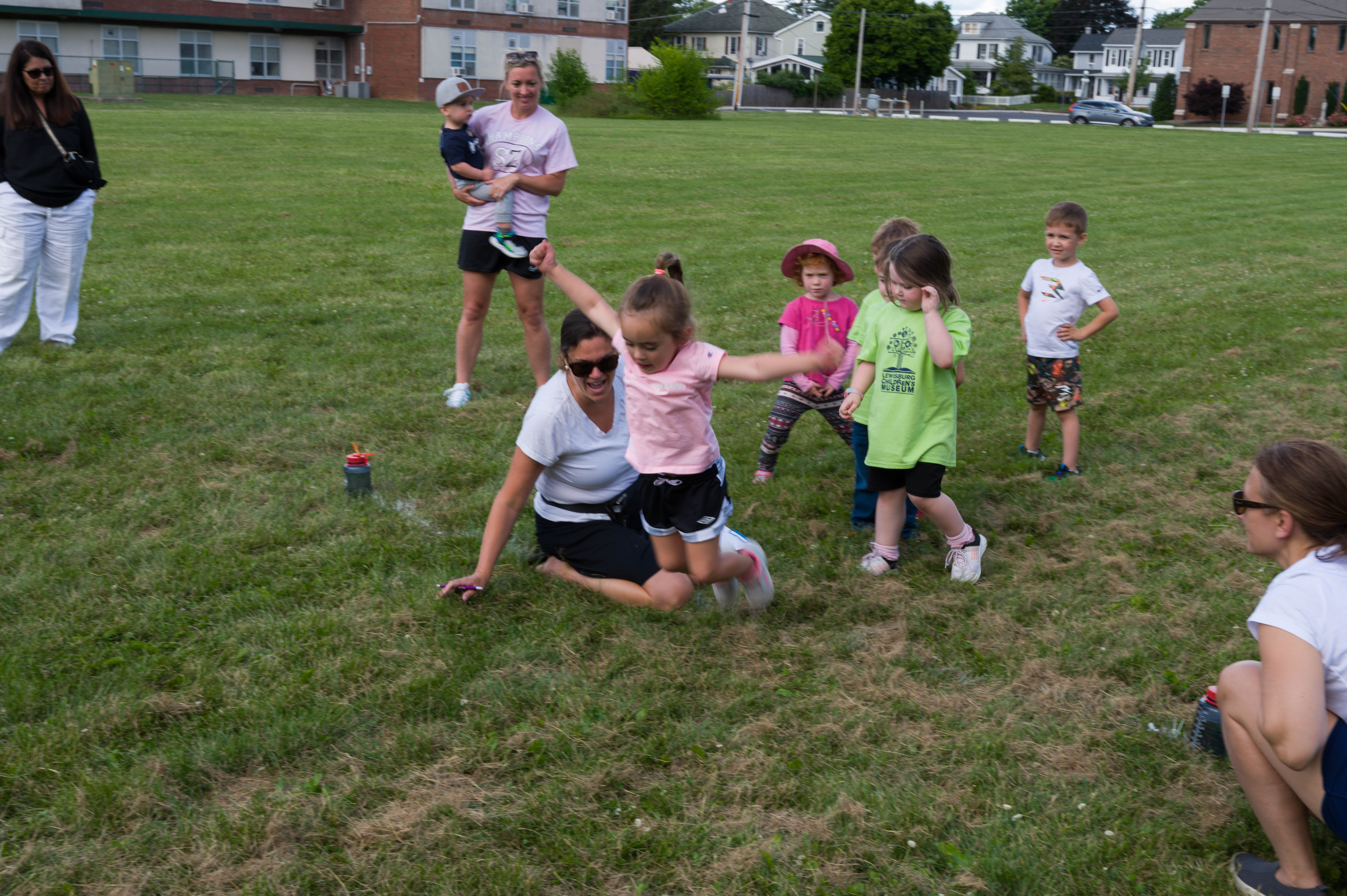 A little girl competes in the long jump.